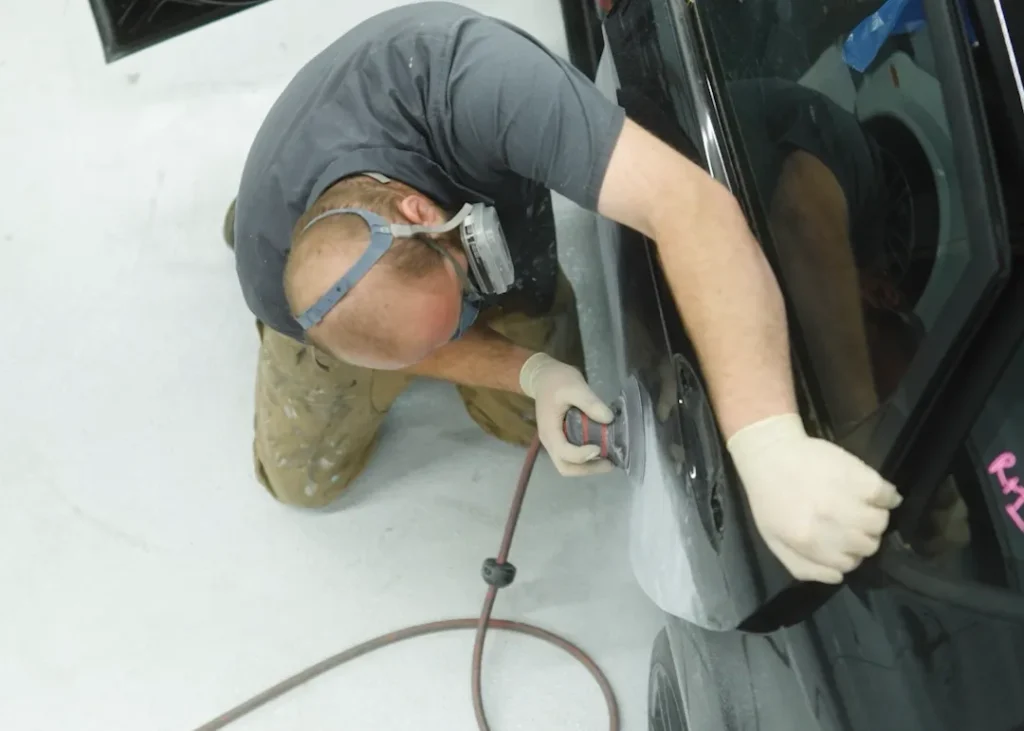 Man sanding a car's surface